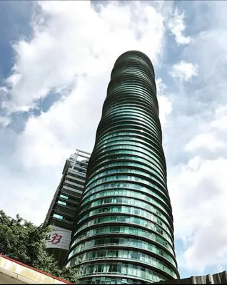 a tall green building with a sky in the background at Atmoods - Vortex KLCC in Kuala Lumpur