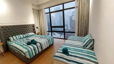 a bedroom with two beds and a large window at Majestic Apartment KLCC in Kuala Lumpur