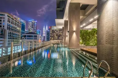 a pool on the roof of a building with a city skyline at Majestic Apartment KLCC in Kuala Lumpur