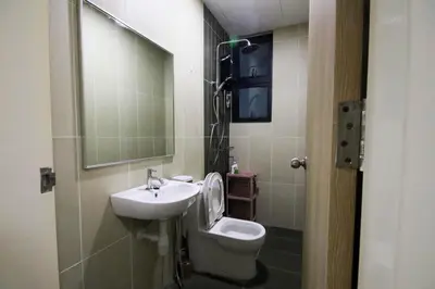 a bathroom with a sink and a toilet and a mirror at Legasi Kampung Baru by Airhost in Kuala Lumpur
