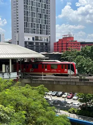 a red train on a bridge in a city at Charming apartment with Netflix at PWTC in Kuala Lumpur