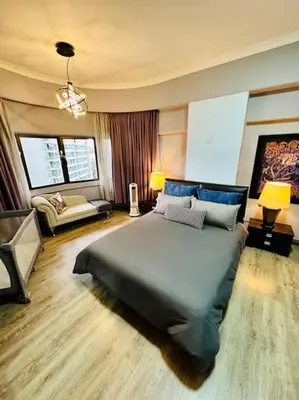 a bedroom with a large bed and a living room at Charming apartment with Netflix at PWTC in Kuala Lumpur