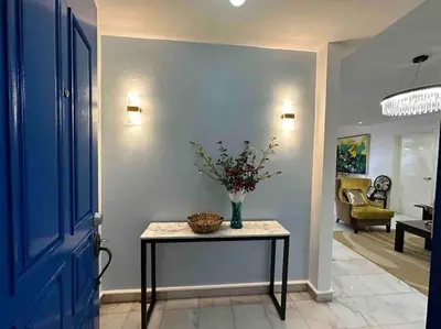 a hallway with a table with a vase of flowers on it at Charming apartment with Netflix at PWTC in Kuala Lumpur