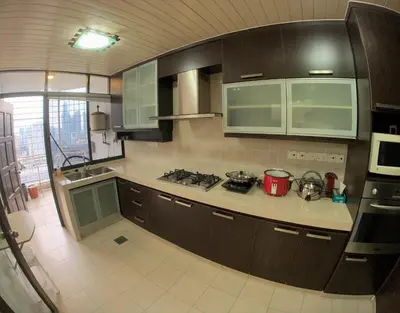 a kitchen with brown cabinets and a counter top at Bukit Bintang Fahrenheit88 Apartment by Sarah's Lodge in Kuala Lumpur