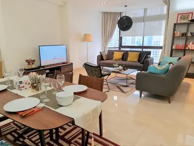 a living room with a table and chairs and a television at Bukit Bintang Fahrenheit88 Apartment by Sarah's Lodge in Kuala Lumpur
