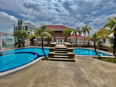 a swimming pool with palm trees in front of a building at Casa Mutiara Apartments by Moonlight in Kuala Lumpur