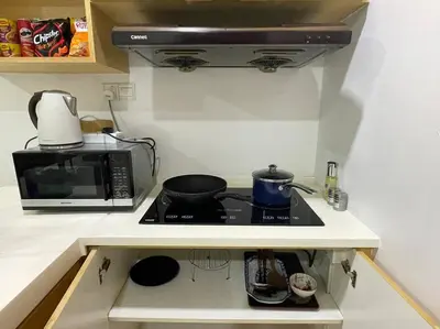 a kitchen with a stove and a microwave at Staycation with Private Jacuzzi @ KL Downtown 1711 in Kuala Lumpur