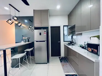 a kitchen with a refrigerator and a counter with stools at Kama Homestay @Wangsa Maju in Kuala Lumpur
