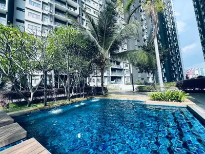 a large blue swimming pool with palm trees and buildings at Kama Homestay @Wangsa Maju in Kuala Lumpur