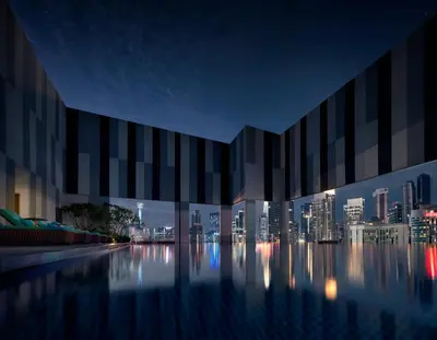 a large building with a city skyline at night at Pan Pacific Serviced Suites Kuala Lumpur in Kuala Lumpur