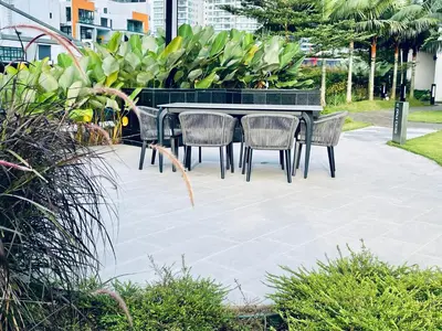 a table and chairs on a patio with plants at Eaton residences KLCC m@h in Kuala Lumpur