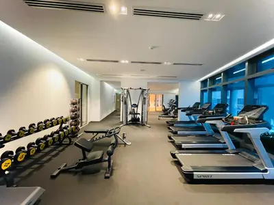 a gym with a row of treadmills and machines at Eaton residences KLCC m@h in Kuala Lumpur