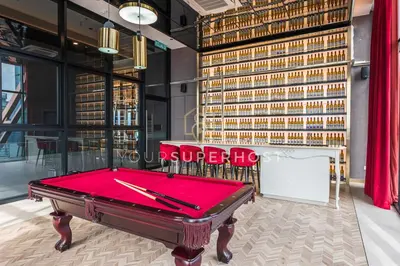 a pool table in a room with a wall of wine bottles at Scarletz Suites near KLCC by YourSuperhost in Kuala Lumpur