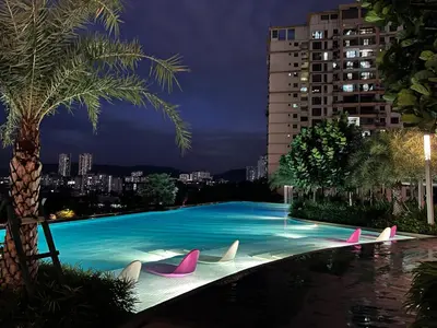 a swimming pool with pink and white chairs in front of a building at PARC 3 in Cheras, #Sunway Velocity #IKEA #TRX in Kuala Lumpur