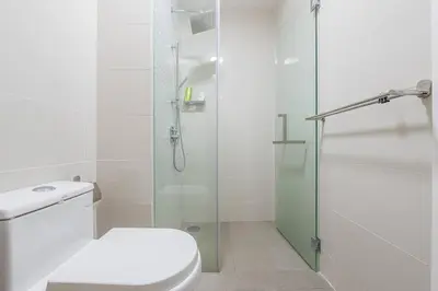 a bathroom with a toilet and a glass shower at Cozy Oasis near Ikea TRX Mall King Size Bed 100mb in Kuala Lumpur