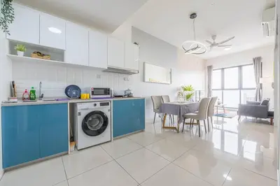 a kitchen with a washing machine and a dining room at Cozy Oasis near Ikea TRX Mall King Size Bed 100mb in Kuala Lumpur