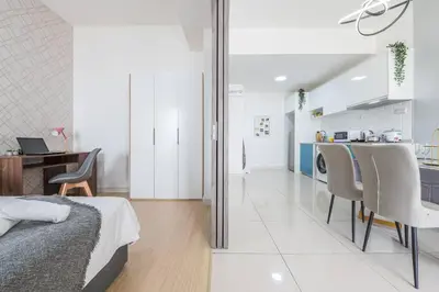 a bedroom with a bed and a desk and a kitchen at Cozy Oasis near Ikea TRX Mall King Size Bed 100mb in Kuala Lumpur