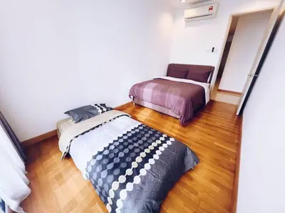 two beds in a room with wood floors at [PROMO]Connected train 2 Bedrooms - Above Mall(25) in Kuala Lumpur