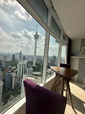 a table and chairs in a room with a view of the seattle skyline at near klcc vortex suites by PLUS POIN in Kuala Lumpur