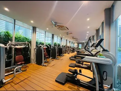 a gym with a row of treadmills and machines at near klcc vortex suites by PLUS POIN in Kuala Lumpur