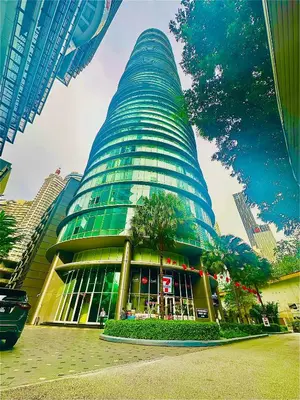 a tall building with a tree in front of it at near klcc vortex suites by PLUS POIN in Kuala Lumpur