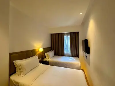 a hotel room with two beds and a tv at D Loft Hotel in Kuala Lumpur