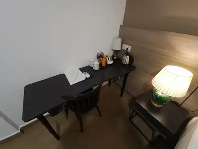 a desk with a lamp and a chair in a room at Yu Hotel Chinatown in Kuala Lumpur