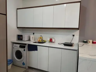 a kitchen with white cabinets and a washing machine at Arte plus by Nicestay in Kuala Lumpur