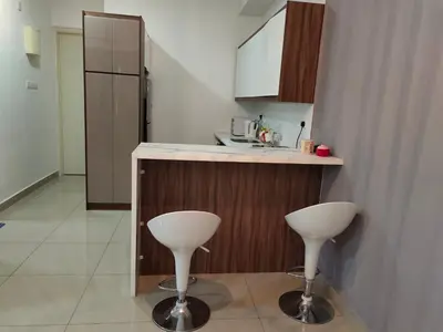a kitchen with two white stools next to a counter at Arte plus by Nicestay in Kuala Lumpur