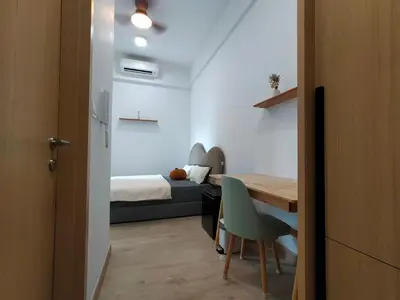 a bedroom with a bed and a desk and a table at Colony ( Wisma Infinitum ) in Kuala Lumpur