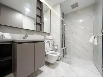 a bathroom with a toilet and a glass shower at The Eaton Residences by Times 8 in Kuala Lumpur