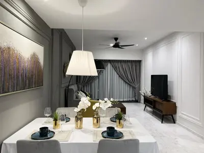 a dining room with a table with chairs and a television at The Eaton Residences by Times 8 in Kuala Lumpur