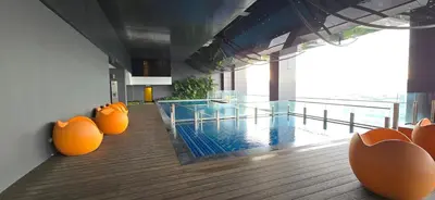a swimming pool with orange chairs in a building at M-City Ampang in Kuala Lumpur