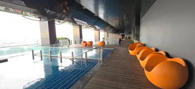 a swimming pool with orange chairs in a building at M-City Ampang in Kuala Lumpur