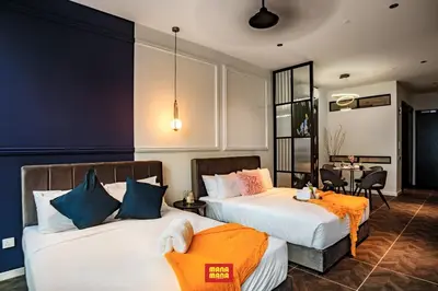 a bedroom with two beds and a dining room at Scarletz Mana-Mana Suites KLCC in Kuala Lumpur
