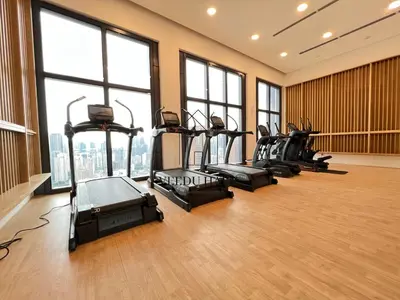 a gym with a row of exercise bikes in a room with windows at Lucentia Residences BBCC at Lalaport Kuala Lumpur by Veedu Hauz in Kuala Lumpur