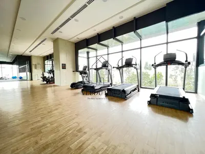 a gym with several treadmills and elliptical machines at Lucentia Residences BBCC at Lalaport Kuala Lumpur by Veedu Hauz in Kuala Lumpur