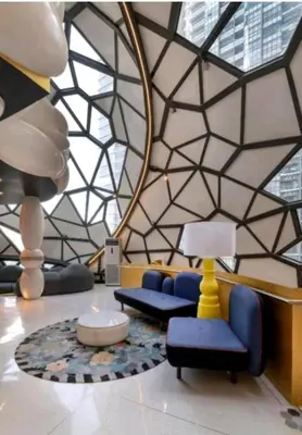 a lobby with blue chairs and a geometric ceiling at Arte Plus AMPANG by Zzzayn in Batu Empat