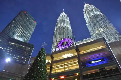 a christmas tree in front of a building with tall buildings at Central 2BR Apt 5 mins to KLCC Twin Towers in Kuala Lumpur