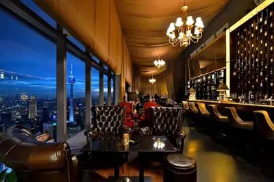a bar with leather chairs and a view of a city at Central 2BR Apt 5 mins to KLCC Twin Towers in Kuala Lumpur