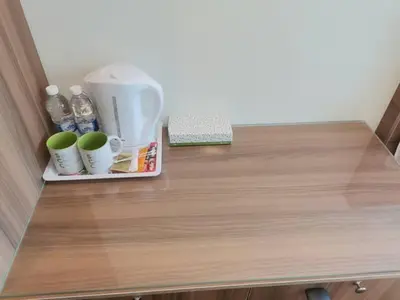 a wooden counter with cups and water bottles on it at SCC Velodrome KL in Kuala Lumpur