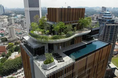 a building with a garden on the top of it at Ceylonz Suites by ROOMY in Kuala Lumpur