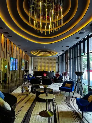 a large lobby with a large chandelier and blue chairs at STAR RESIDENCE KLCC in Kuala Lumpur