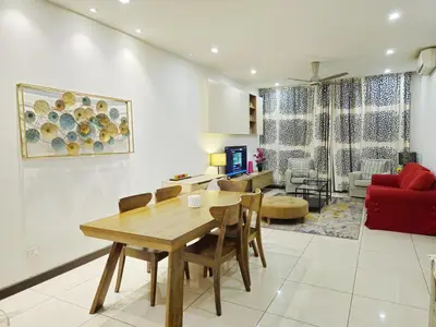 a living room with a table and a red couch at Blue Sky Apartment in Kuala Lumpur