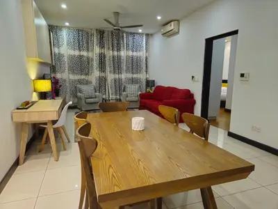 a living room with a wooden table and a red couch at Blue Sky Apartment in Kuala Lumpur