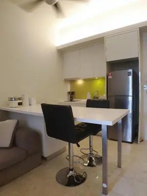 a kitchen with a white table and a refrigerator at The Signature & Hotel Suites Mont Kiara Kuala Lumpur in Kuala Lumpur