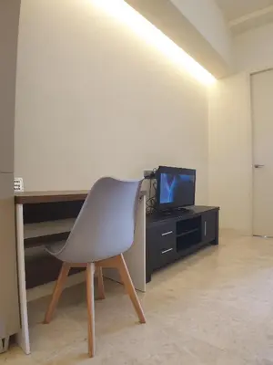 a chair in a room with a desk and a television at The Signature & Hotel Suites Mont Kiara Kuala Lumpur in Kuala Lumpur