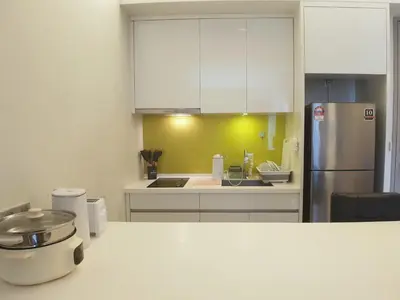 a kitchen with white cabinets and a refrigerator at The Signature & Hotel Suites Mont Kiara Kuala Lumpur in Kuala Lumpur