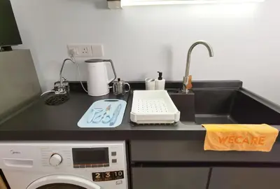 a kitchen counter with a sink and a washing machine at The Blueprint @ Bangsar South Mid Valley in Kuala Lumpur