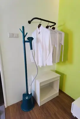 a room with a broom and a white shirt on a rack at The Territory @ Bangsar South Mid Valley in Kuala Lumpur